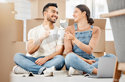 Image of Cheers to us making this all come true. a young couple sitting on the floor and drinking coffee while moving house.