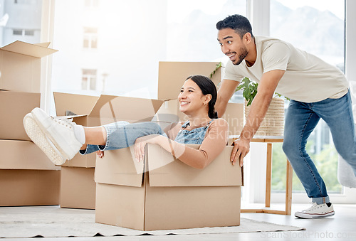 Image of Get ready for a cruise around your new home. a young couple playing with boxes while moving house.