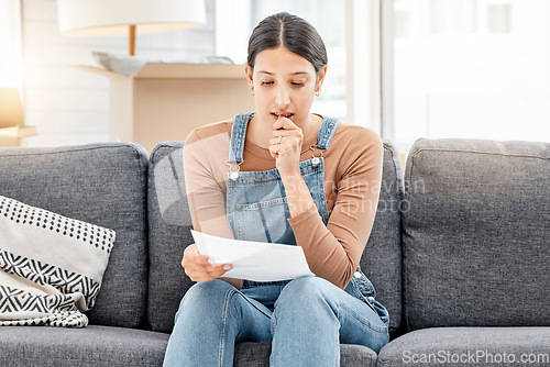 Image of I dont have a plan B...a young woman anxiously biting her nails and reading a letter while moving house.