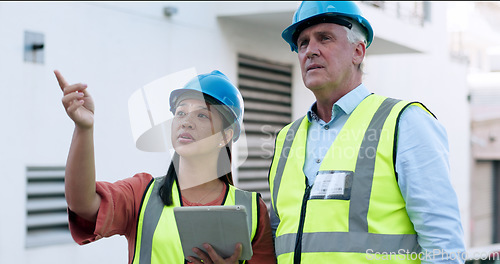 Image of Construction, team and tablet for inspection with people at job site, mentor and apprentice with communication. Architecture, engineering and digital floor plan, old man and woman outdoor in meeting