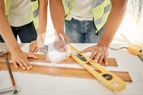 Image of Adding some texture to the home. two unrecognisable construction workers standing together and using a ruler to measure a beam of wood.