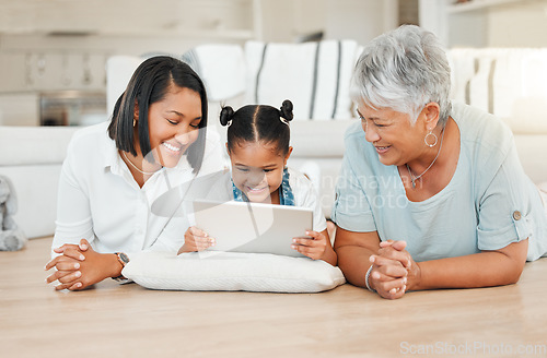 Image of The most important thing in the world is family. a young family happily bonding while using a digital tablet at home.