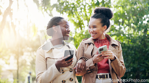 Image of Phone, social media and woman friends outdoor walking in the park together during summer with flare. Smile, fashion influencer and young content creator people in a garden for mobile communication