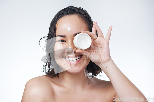 Image of This will help your skin look flawless for many years to come. a beautiful young woman holding up a pot of moisturiser.