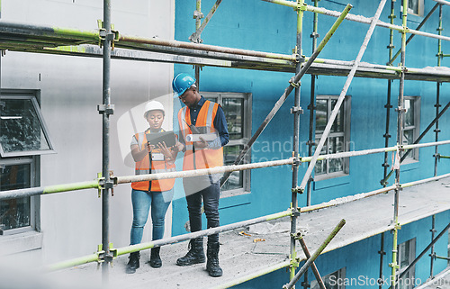 Image of Adopting technology to ramp up the development on a new site. a young man and woman using a digital tablet while working at a construction site.
