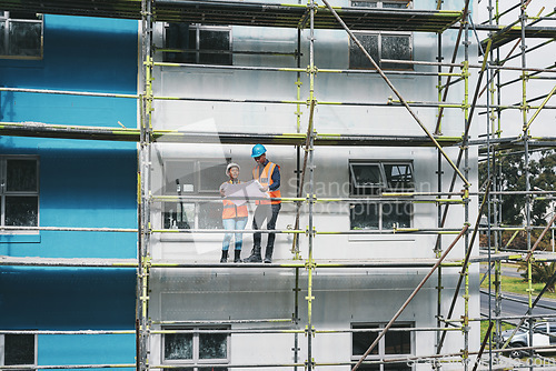 Image of Designing and signing off on contracts. a young man and woman going over building plans at a construction site.