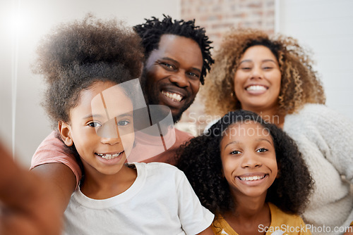 Image of Smiling together, staying together. a young family taking a selfie at home.