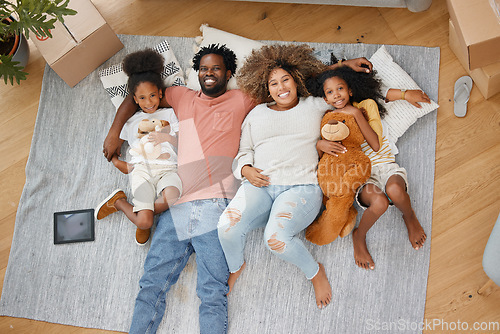 Image of Forming family bonds. Aerial shot of a young family lying on the floor at home.