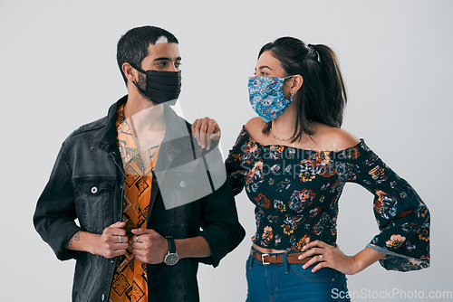 Image of Face masks just upped our fashion game. Studio shot of a masked young man and woman posing against a grey background.