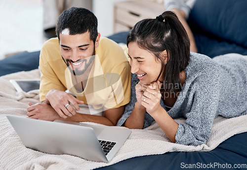 Image of The better the wifi the better the entertainment. a young couple using a laptop together in bed.