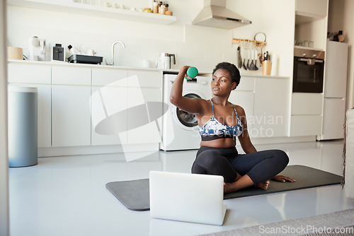 Image of Regular exercise can become a rewarding habit. a young woman using a laptop while exercising at home.