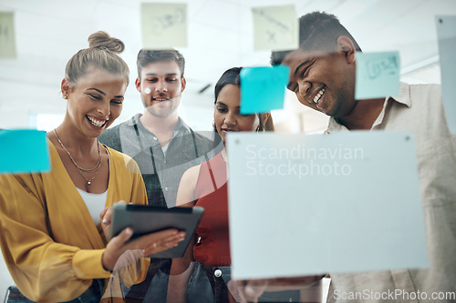 Image of A little inspiration can kickoff a whole lot more. a group of businesspeople using a digital tablet while brainstorming with notes on a glass wall in an office.