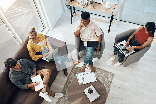 Image of Getting together to come up with some innovative ideas. High angle of a group of businesspeople having a discussion in an office.