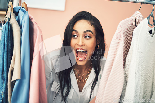 Image of Its competition time and you this collection could be yours. a young woman sticking her head in between items on a clothing rail.