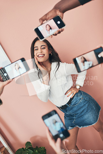 Image of Everyone wants to know her secret. a beautiful young woman having her picture taken on multiple phones.