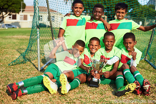 Image of Players win games, teams win championships. Portrait of a boys soccer team posing with their trophy on a sports field.