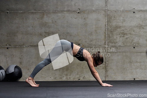 Image of Fit woman in a modern gym working flexibility and strength through various exercises, demonstrating her commitment to fitness