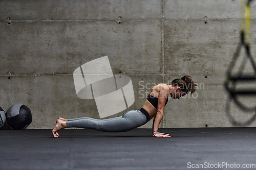 Image of Fit woman in a modern gym working flexibility and strength through various exercises, demonstrating her commitment to fitness