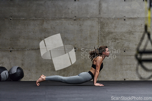 Image of Fit woman in a modern gym working flexibility and strength through various exercises, demonstrating her commitment to fitness
