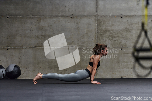 Image of Fit woman in a modern gym working flexibility and strength through various exercises, demonstrating her commitment to fitness