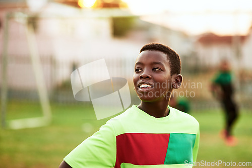 Image of Playing a sport is a great way for kids to loosen up. a young boy playing soccer on a sports field.