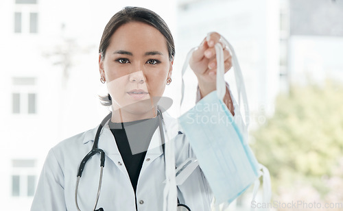 Image of A face mask a day, keeps the doctor away. a medical practitioner holding up a face mask.