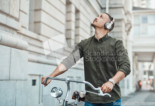 Image of The world is too wide not to find opportunity. a young businessman riding a bicycle in the city.