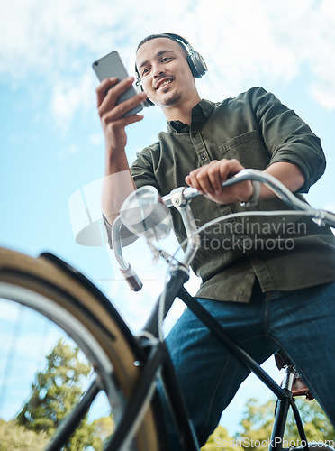 Image of To make things happen youve got to stay mobile. a young businessman using a smartphone while riding his bicycle in the city.