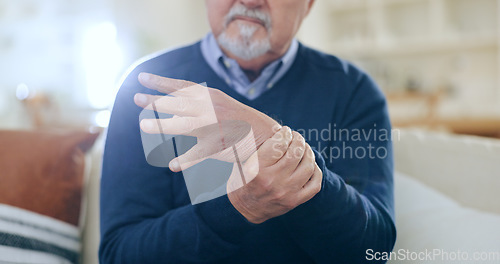 Image of Home, injury and senior man with wrist pain, bruise or inflammation with muscle tension in a lounge. Pensioner, old person and elderly guy on a sofa, accident or emergency with arthritis or broken