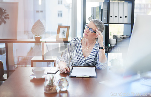 Image of Am I making the right decisions for my business. a mature businesswoman going through paperwork in an office.