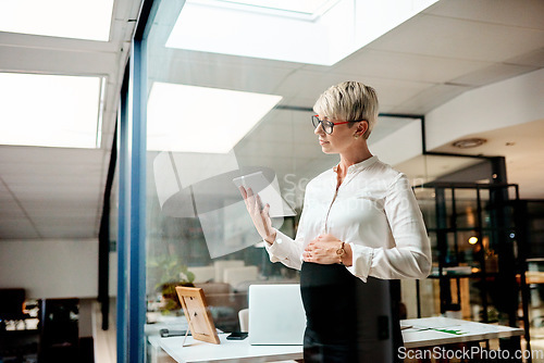 Image of Managing your pregnancy while working can be quite the juggling act. a pregnant businesswoman using a digital tablet in an office.