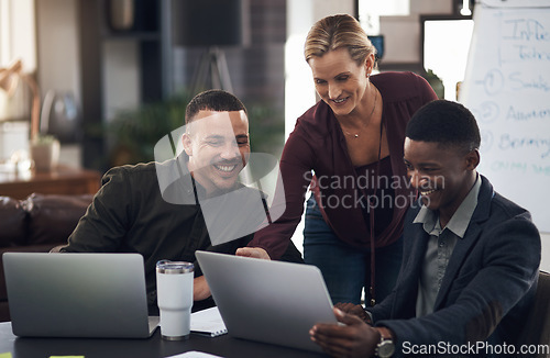 Image of Perfecting the little touches to their big plan. a group of businesspeople working together on a laptop in an office.