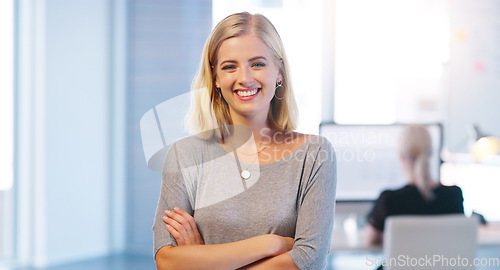 Image of Everything is running smoothly today. Portrait of a confident young businesswoman standing with her arms folded inside of the office.