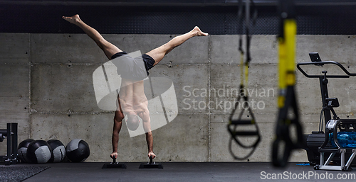 Image of A muscular man in a handstand position, showcasing his exceptional balance and body control while performing a variety of exercises to enhance his overall body stability and strength in a modern gym