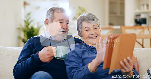 Image of Tablet, coffee and a senior couple in their home to relax together during retirement for happy bonding. Technology, smile or love with an elderly man and woman drinking tea in their living room