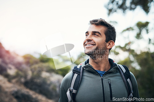 Image of What a beautiful day for a hike. a cheerful young man looking into the distance while going for a hike up a mountain.