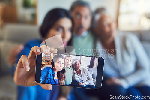 Image of She brings so much joy into our lives. a cheerful senior couple and their daughter taking a selfie together while sitting on a couch at home.