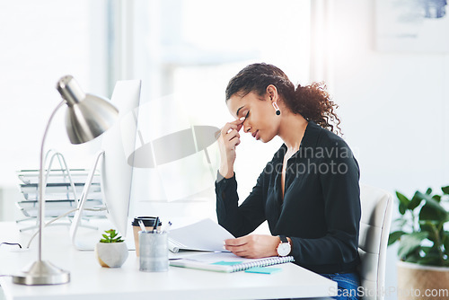 Image of Beware the chair - excessive sitting can lead to tension headaches. a young businesswoman looking stressed out while working in an office.