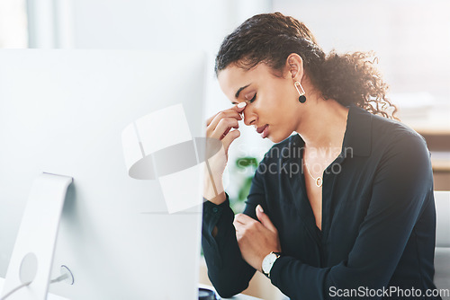 Image of I really need to find relief from this pain. a young businesswoman looking stressed out while working in an office.