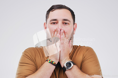 Image of But how. Studio shot of a young man looking shocked against a grey background.