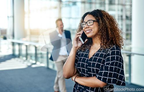 Image of Creating happy clients is her passion. an attractive young businesswoman taking a phonecall while standing in a modern workplace.