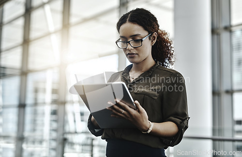 Image of The goal is to work efficiently. an attractive young businesswoman using a digital tablet in a modern office.