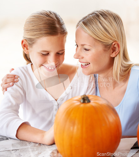 Image of Your pumpkin is going to look amazing. a mother and daughter carving a pumpkin together.