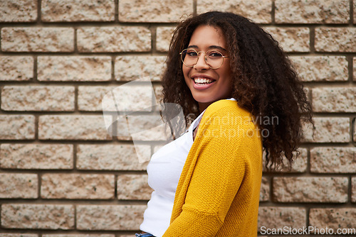 Image of Happiness lives in me. Cropped portrait of a happy young woman posing against a brick wall.