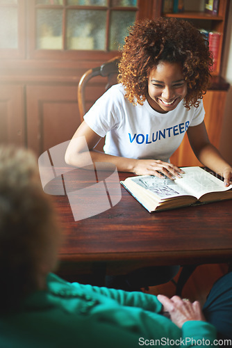 Image of Giving a little goes a long way. a volunteer reading to a senior woman at a retirement home.