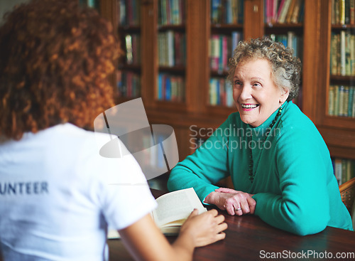 Image of Smiles are the only reward one needs. a volunteer reading to a senior woman at a retirement home.