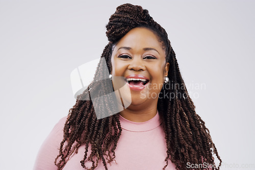 Image of Having a little fun with it. Studio portrait of an attractive young woman laughing while standing against a grey background.