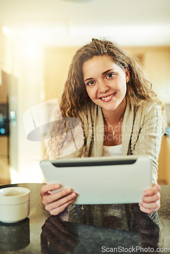 Image of Weekends are for happy browsing. Portrait of an attractive young woman using her digital tablet at home.