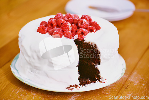 Image of Berries on cloud nine. a delicious chocolate cake with frosting and raspberries.