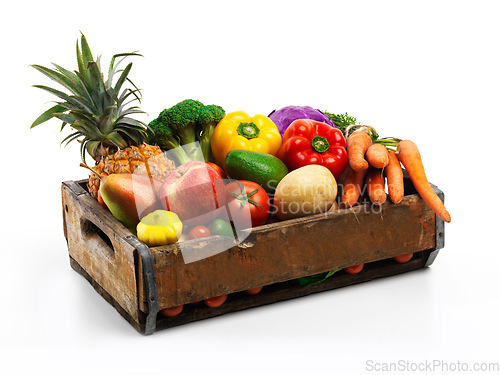 Image of Overflowing with natures bounty. Studio shot of a box full of fresh vegetables and fruit against a white background.